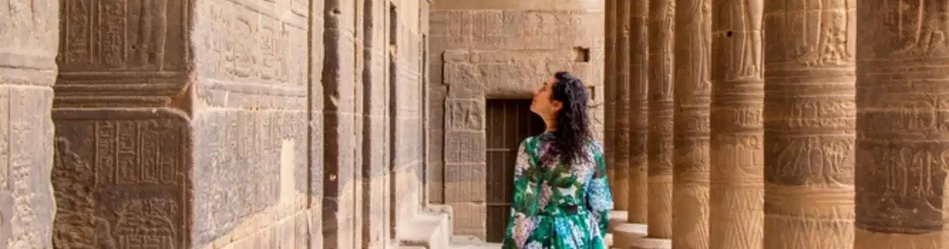 Tourist standing in front of Philae Temple, a part of our 6 Days Budget Nile Cruise Tour Package from Cairo