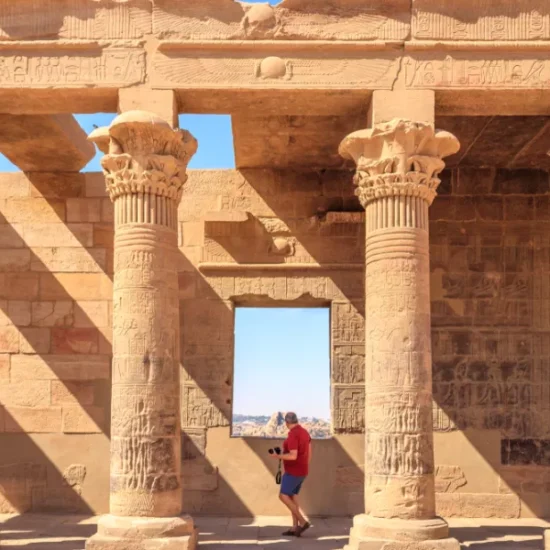 Tourist standing in front of Philae Temple, during our 6 Days Cairo, Luxor & Aswan Affordable Tour