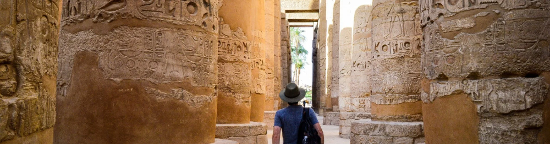 Tourist standing at Karnak Temple from behind as a part of our 6 Days Cairo, Luxor, Aswan and Abu Simbel Budget Tour
