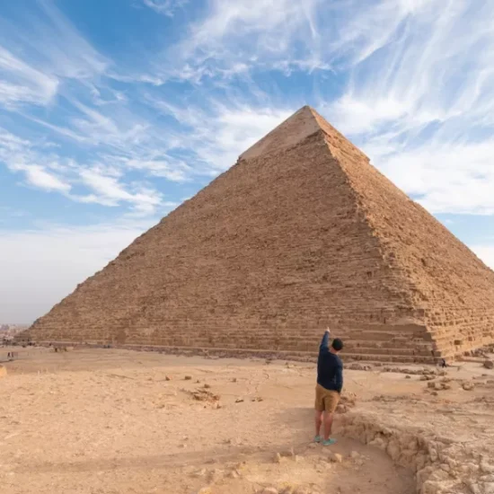 Tourist standing in front of the Great Pyramid of Giza