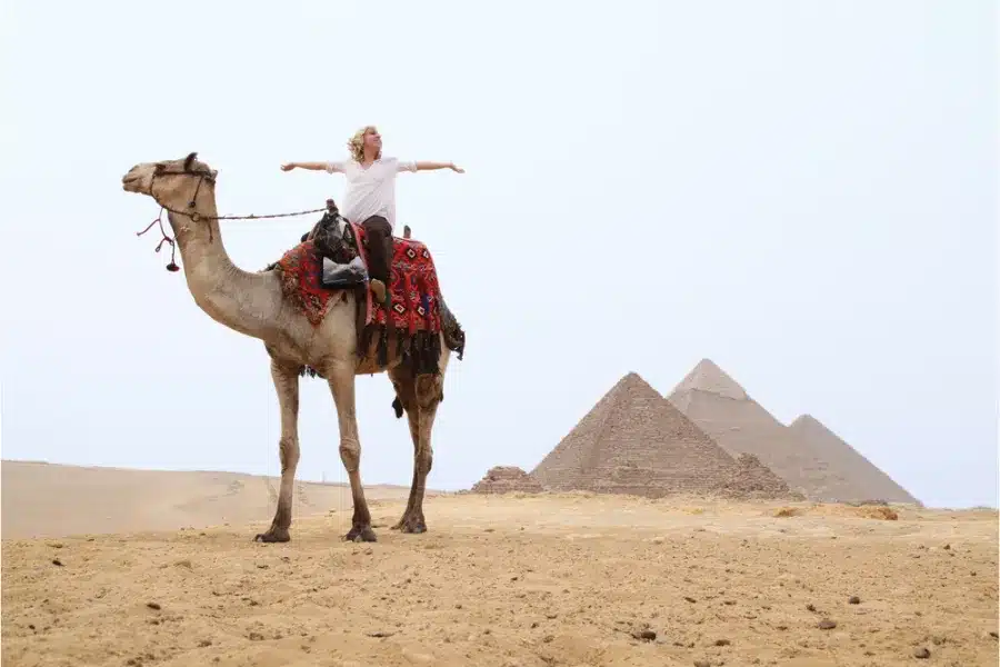 Solo traveller riding a camel near the Giza Pyramids in Egypt