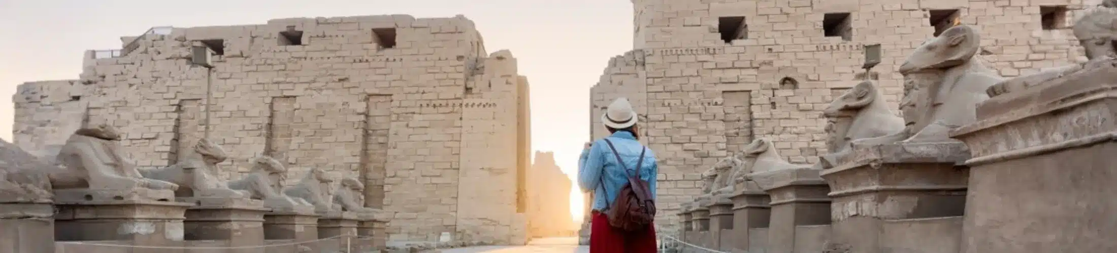 Solo traveller walking through Karnak Temple in Luxor Egypt