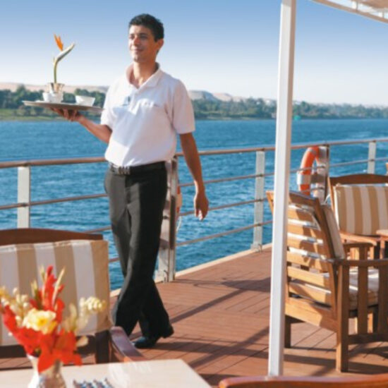 Waiter serving guests aboard River Tosca Nile Cruise